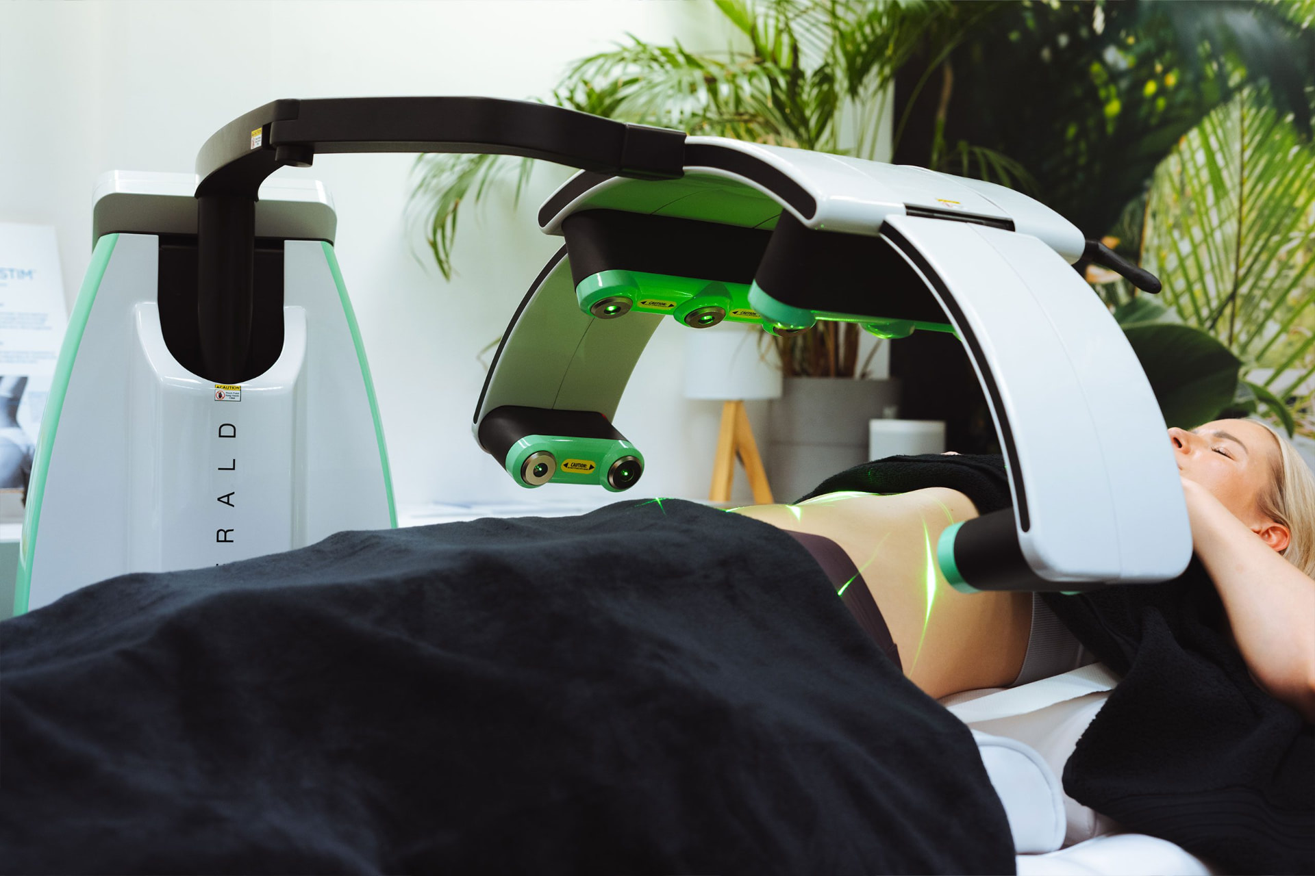 Emerald Laser delivering green laser energy to a patient's abdomen during a treatment session